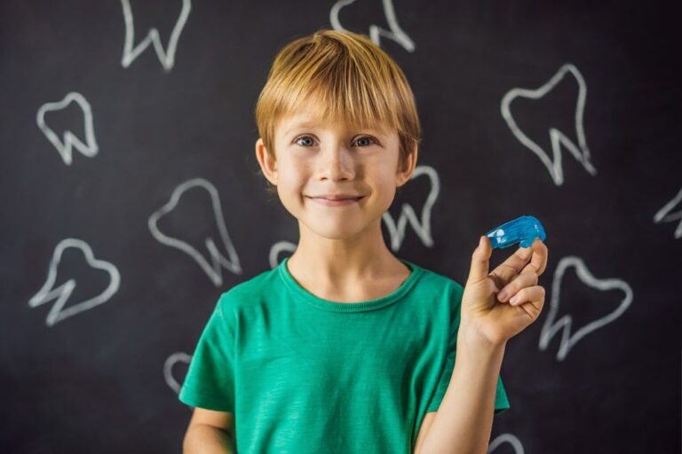 Boy holding a blue retainer.